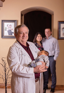 Dr. Tallerico stands with the last baby he delivered and the family