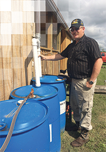Bill Alford with their rainwater collection barrels