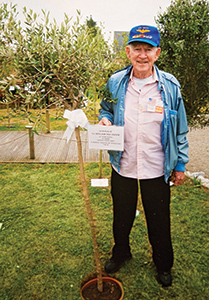 Bill Van Osdol with his tree and plaque in Normandy